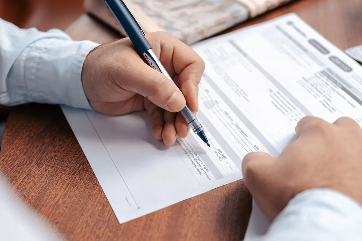 A person completing a paper document
