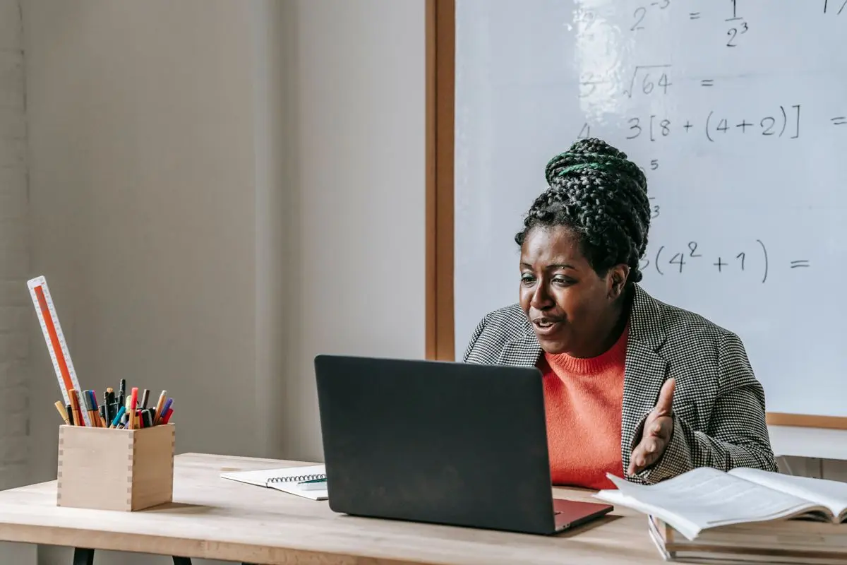 A teacher preparing a lesson at a laptop