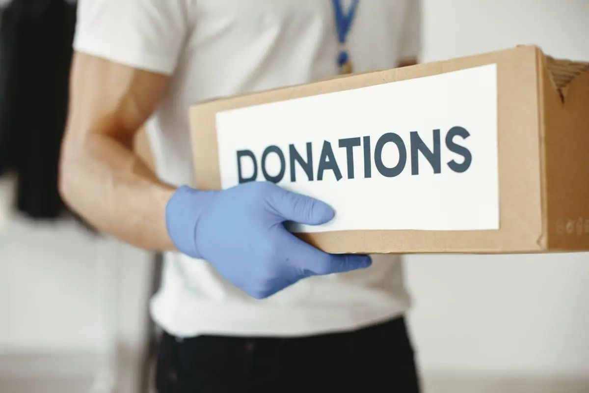 A volunteer carrying a box of donations