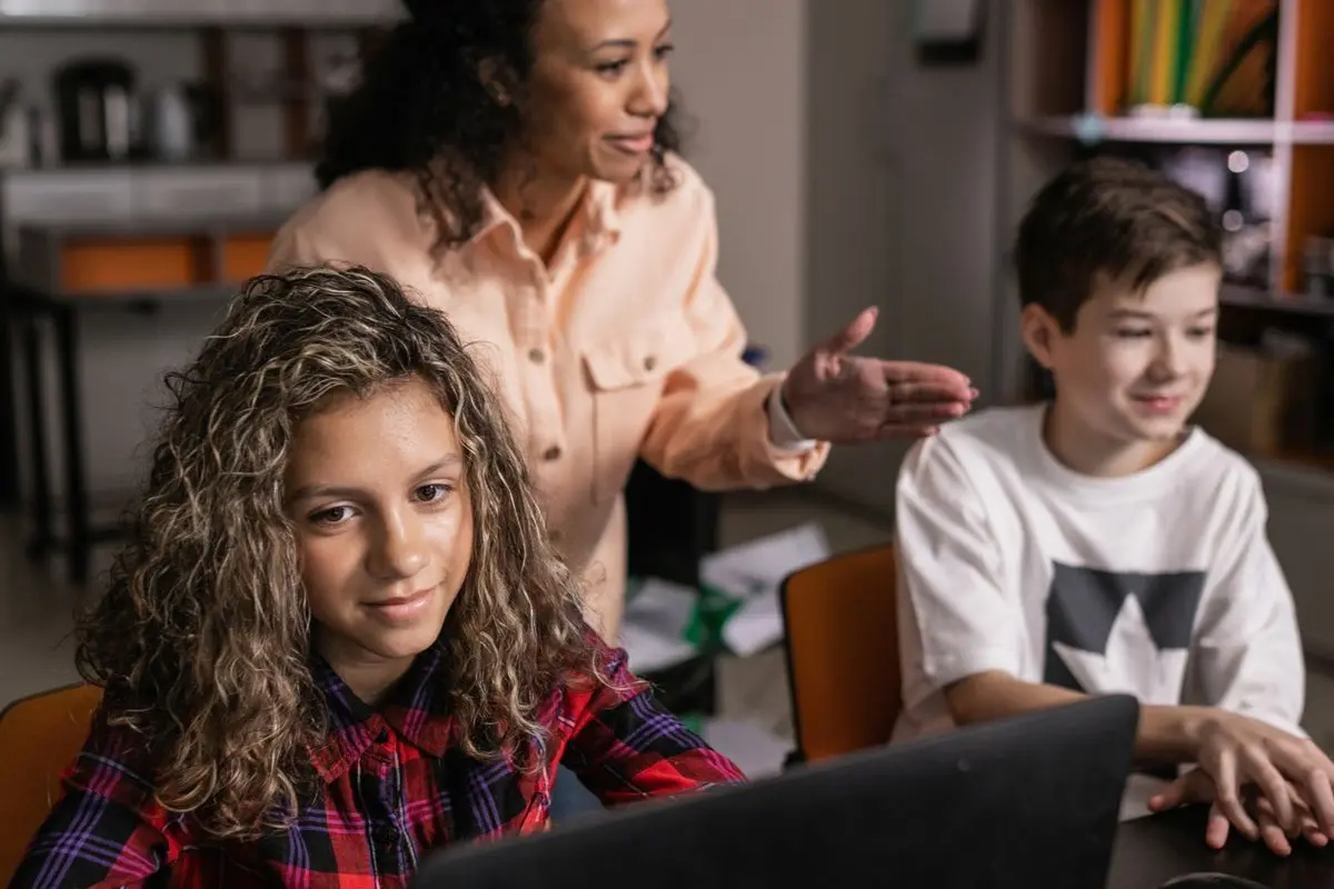 A teacher assisting pupils at their desks