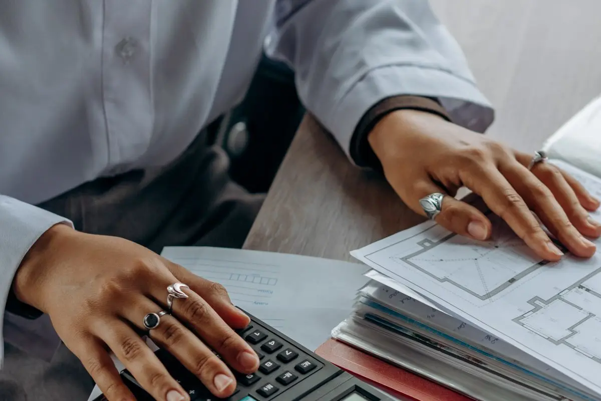 A person using a calculator beside paperwork