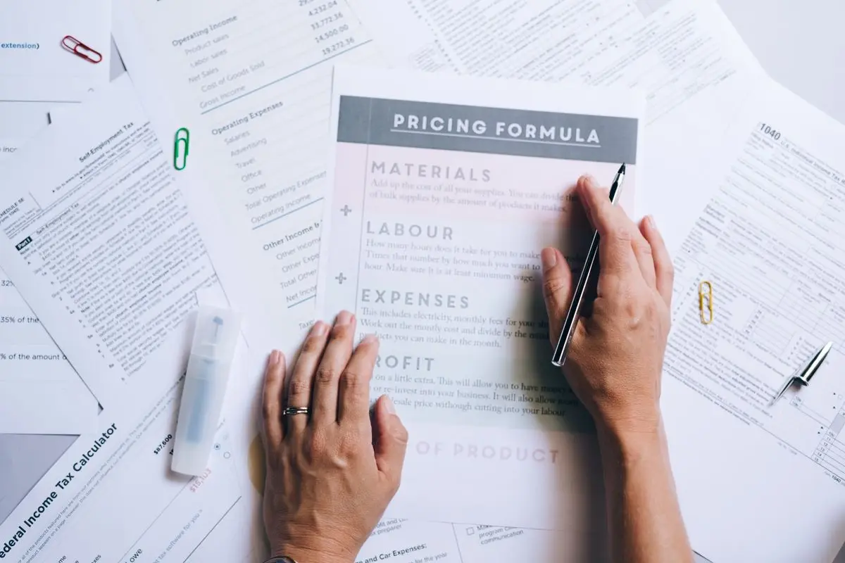 Hands comparing information on printed documents