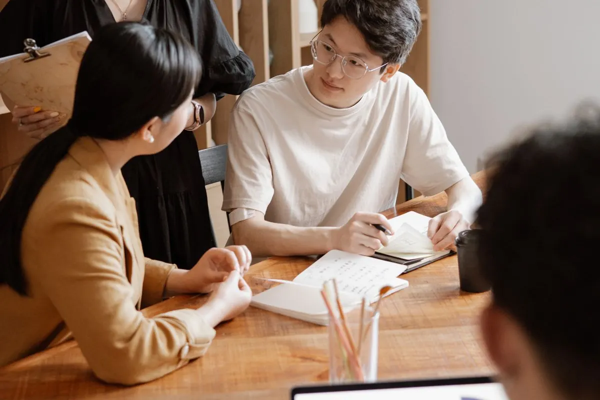 Colleagues discussing work around an office table